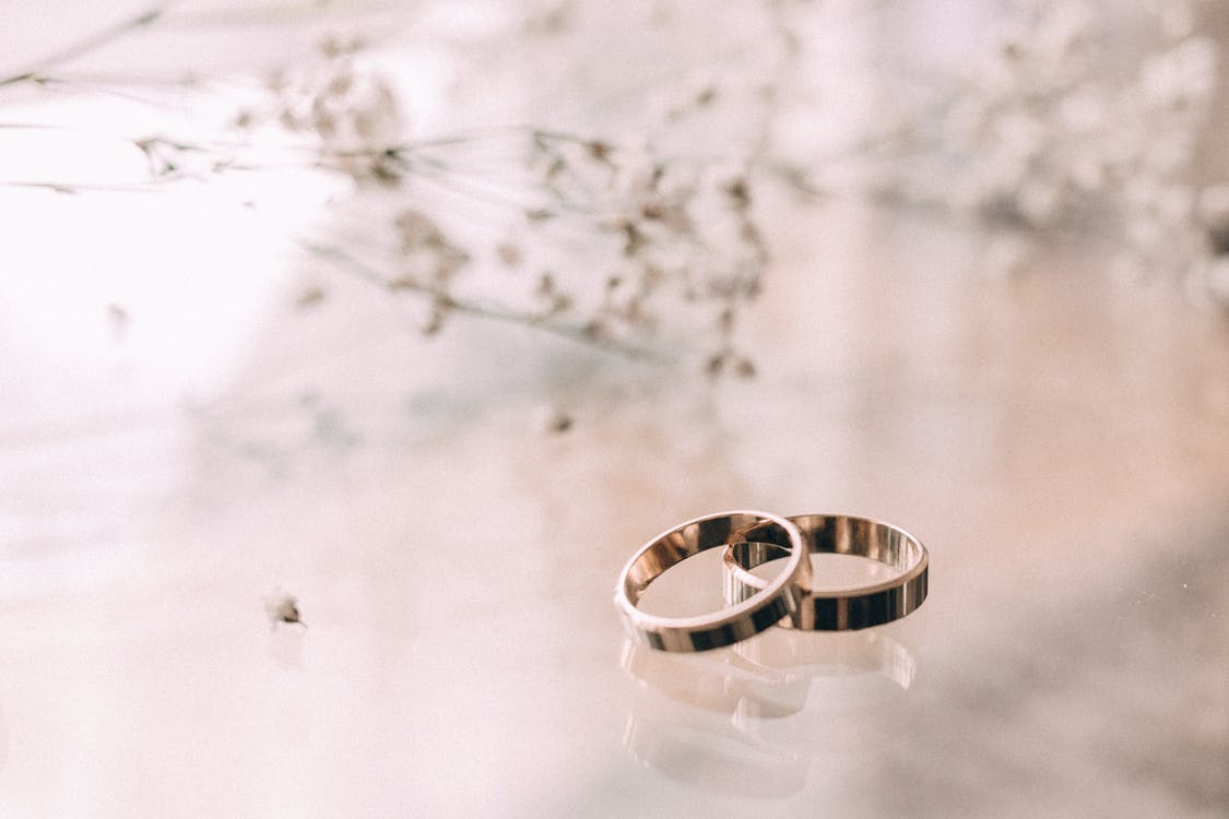Free Two Silver-colored Rings on Beige Surface Stock Photo